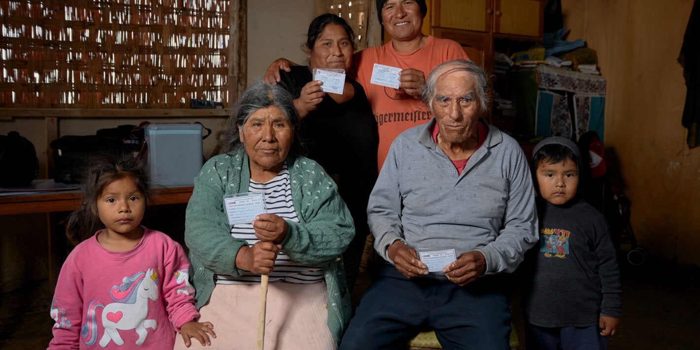 family holding up their vaccination cards at home