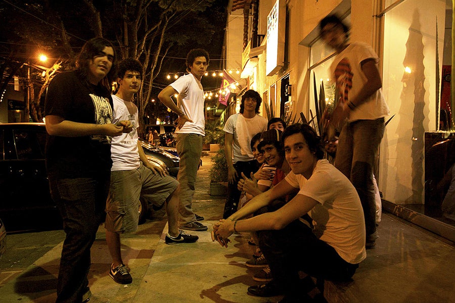 Group of young males outside on the street at night.