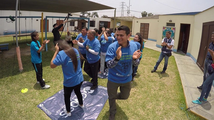 Families and trainers dancing during the Familias Fuertes program in Peru.