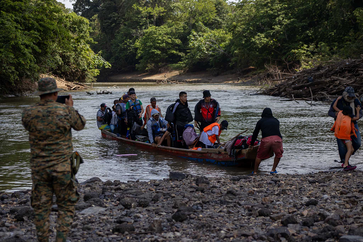 Migrants move by boat through the Darien region