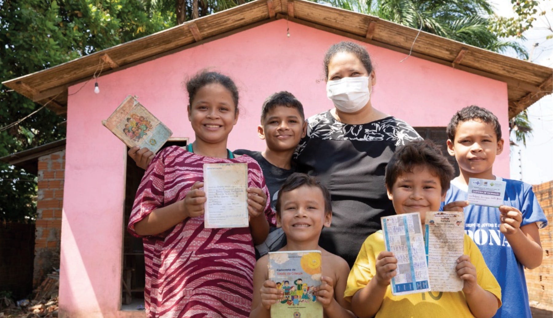 A family in a riverside community in Amapá, northern Brazil, display their vaccination certificates.