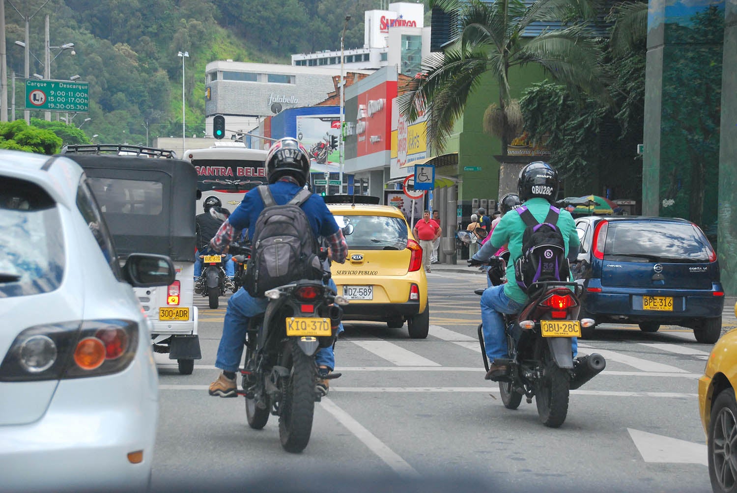 Vehículos y motos en una calle, motociclistas con casco