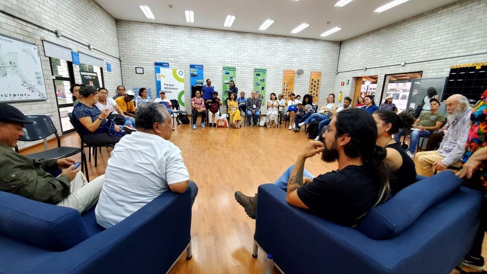 Grupo de personas reunidas en un círculo aprendiendo