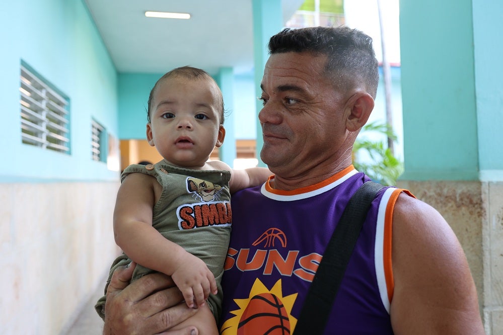 Niño cubano vacunado, padre feliz