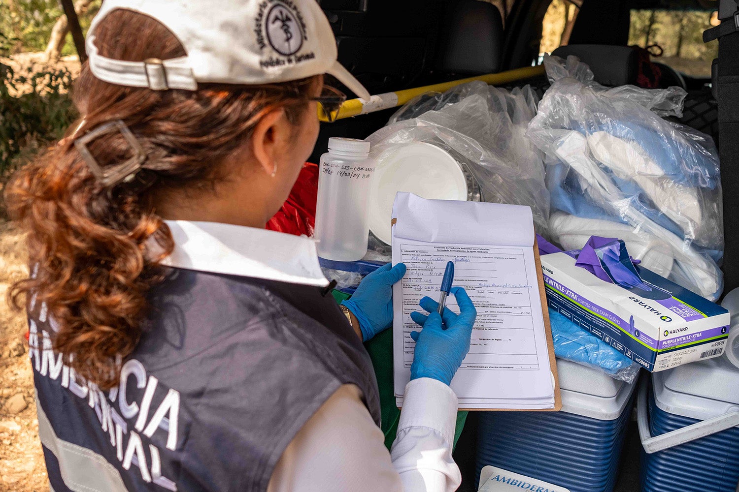 Completando el formulario para recolección de muestras de aguas residuales en uno de los sitios de muestreo, San Juan Sacatepéquez, Guatemala.