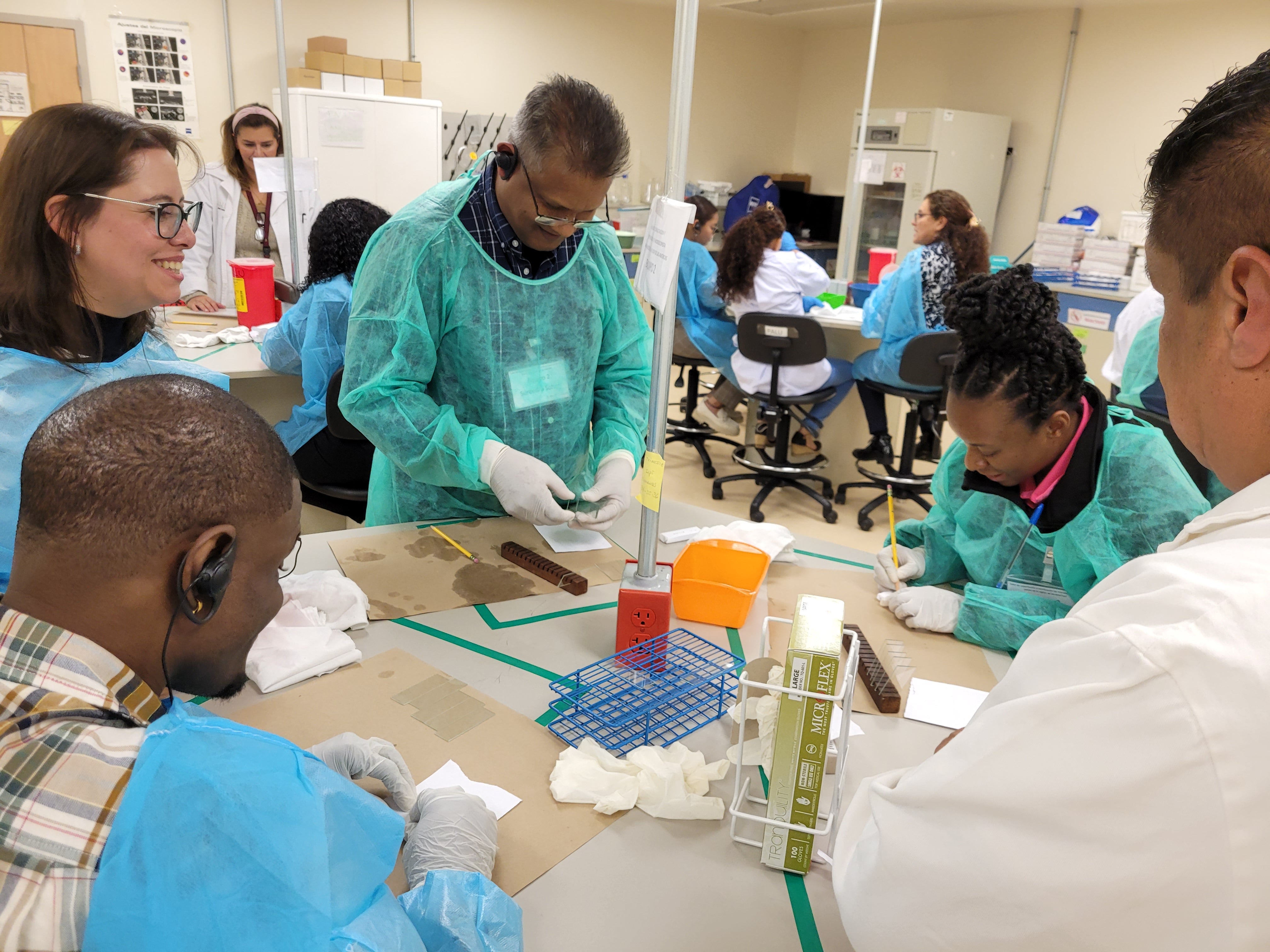 Especialistas que participaron en el taller, sentados haciendo observaciones en el microscopio