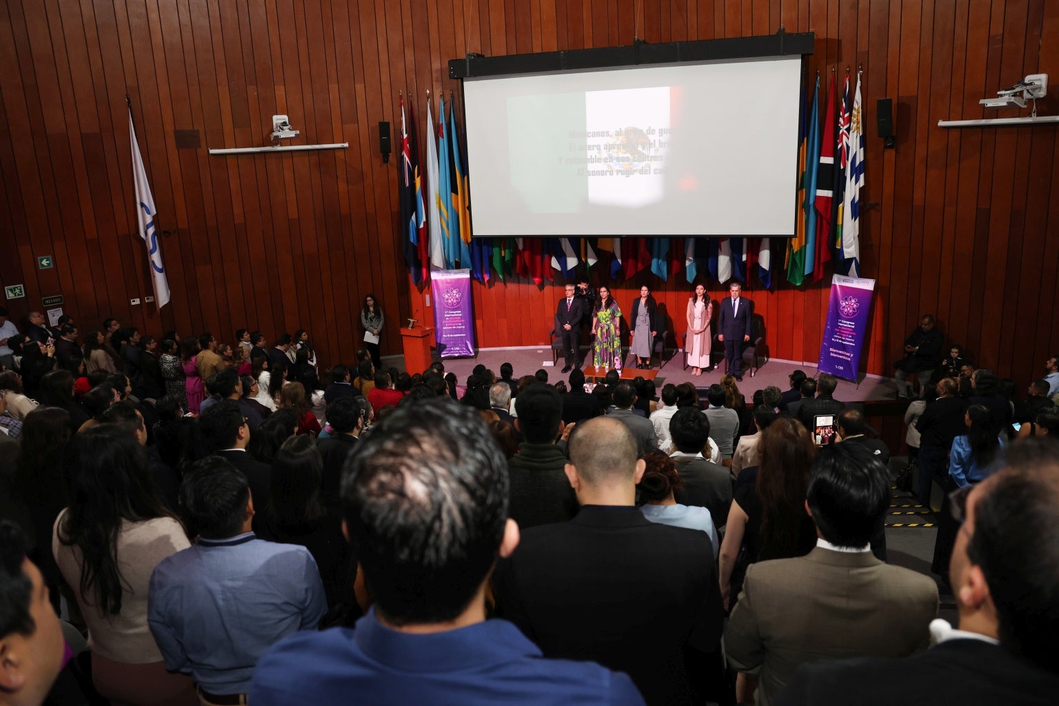 Foto panorámica del auditorio, se observa el público asistente y al fondo las personalidades del presidium