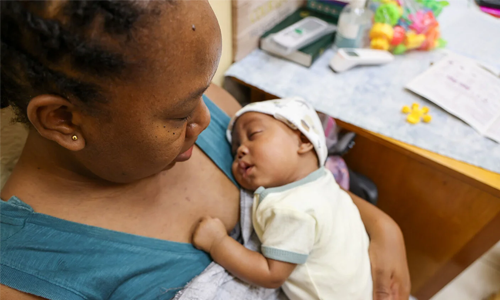 Madre mirando a su bebé mientras lo controla un medico