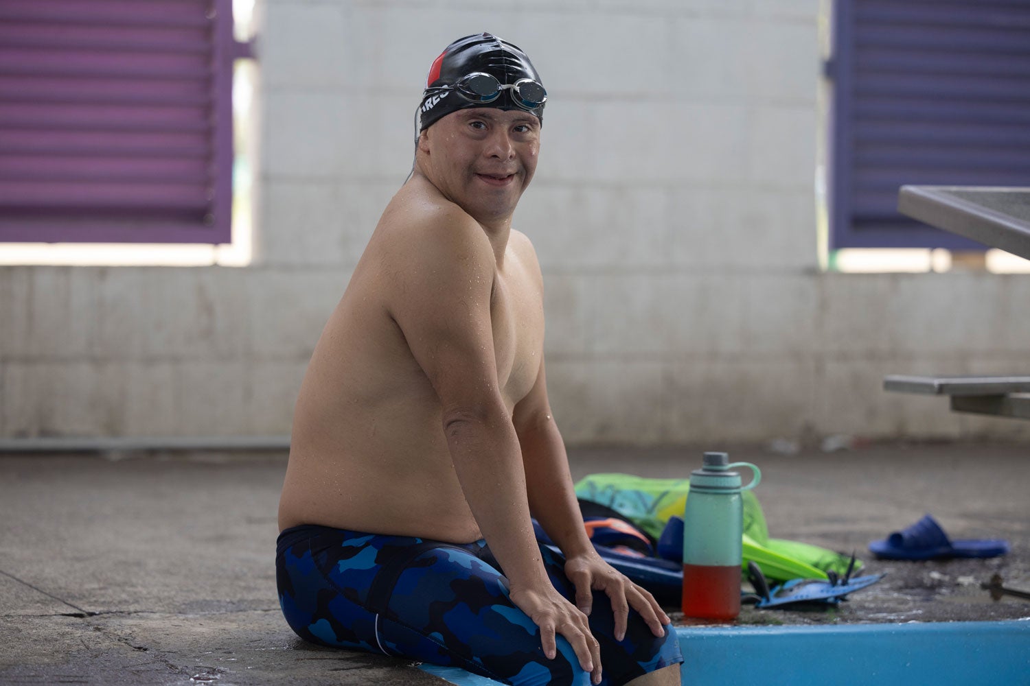 Giovanni posa en el borde de la piscina de UTUPIA, donde nada con frecuencia