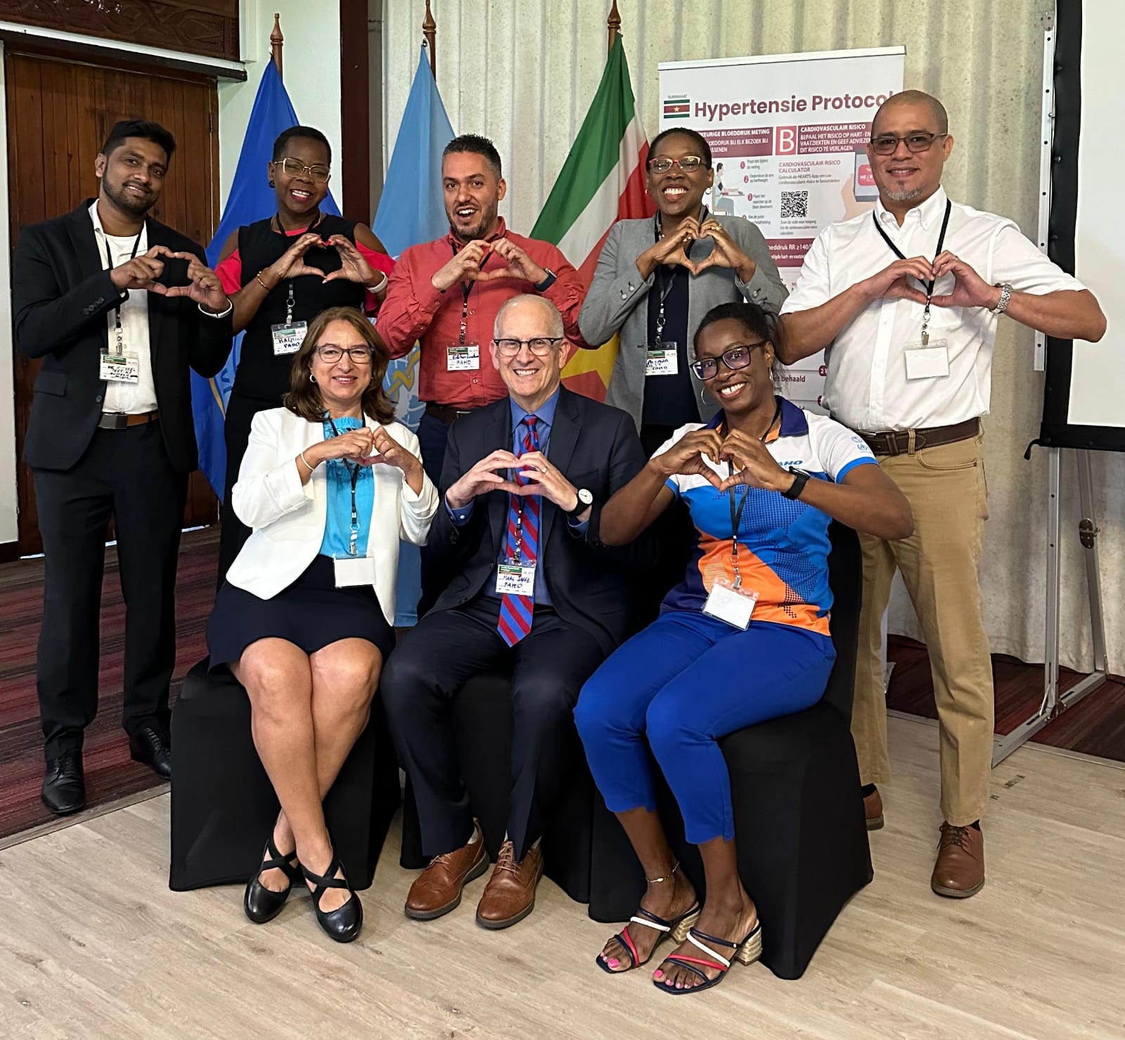 Regional PAHO experts during the HEARTS Initiative Mission in Suriname pose making a heart with their hands