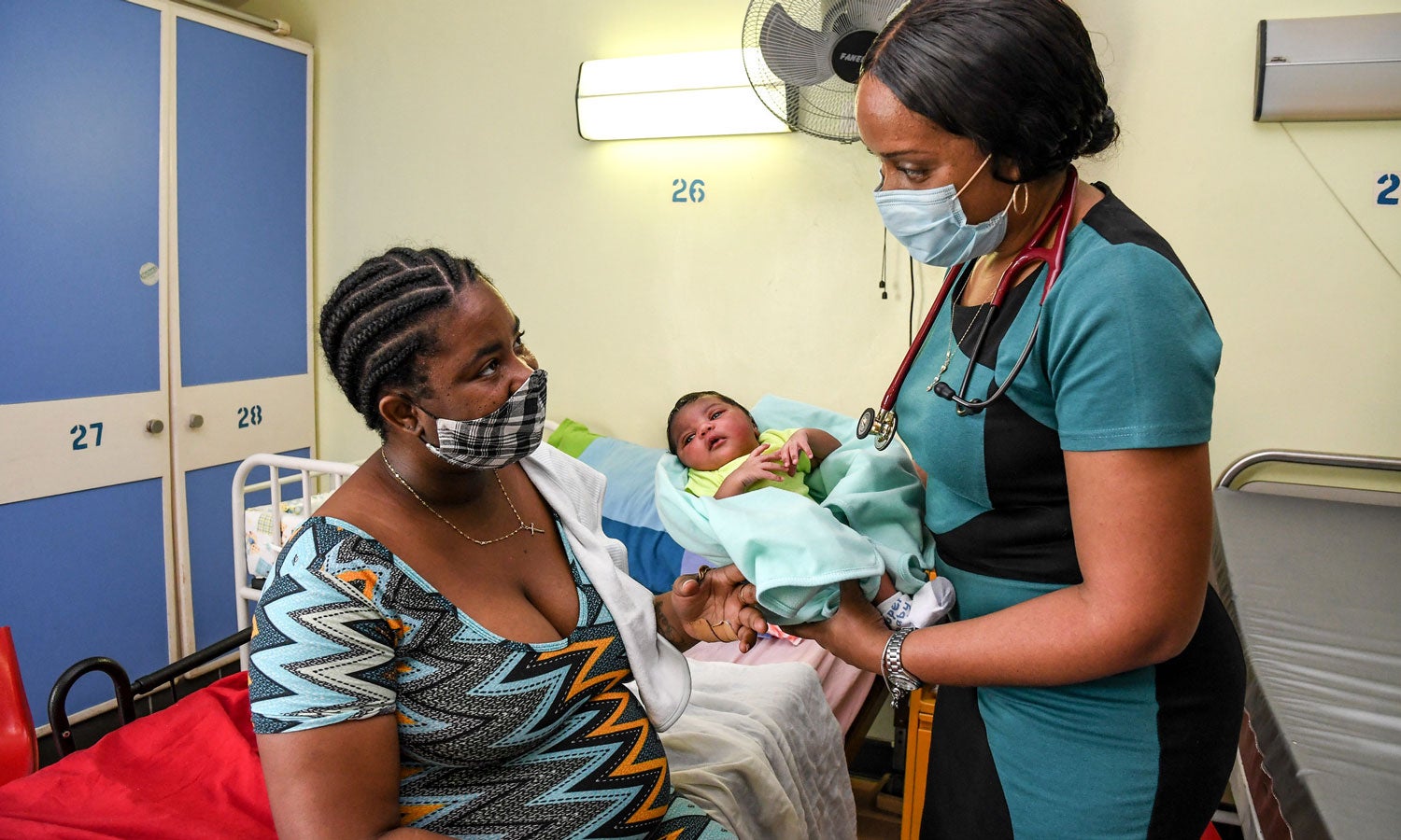 nurse handing mother a newborn