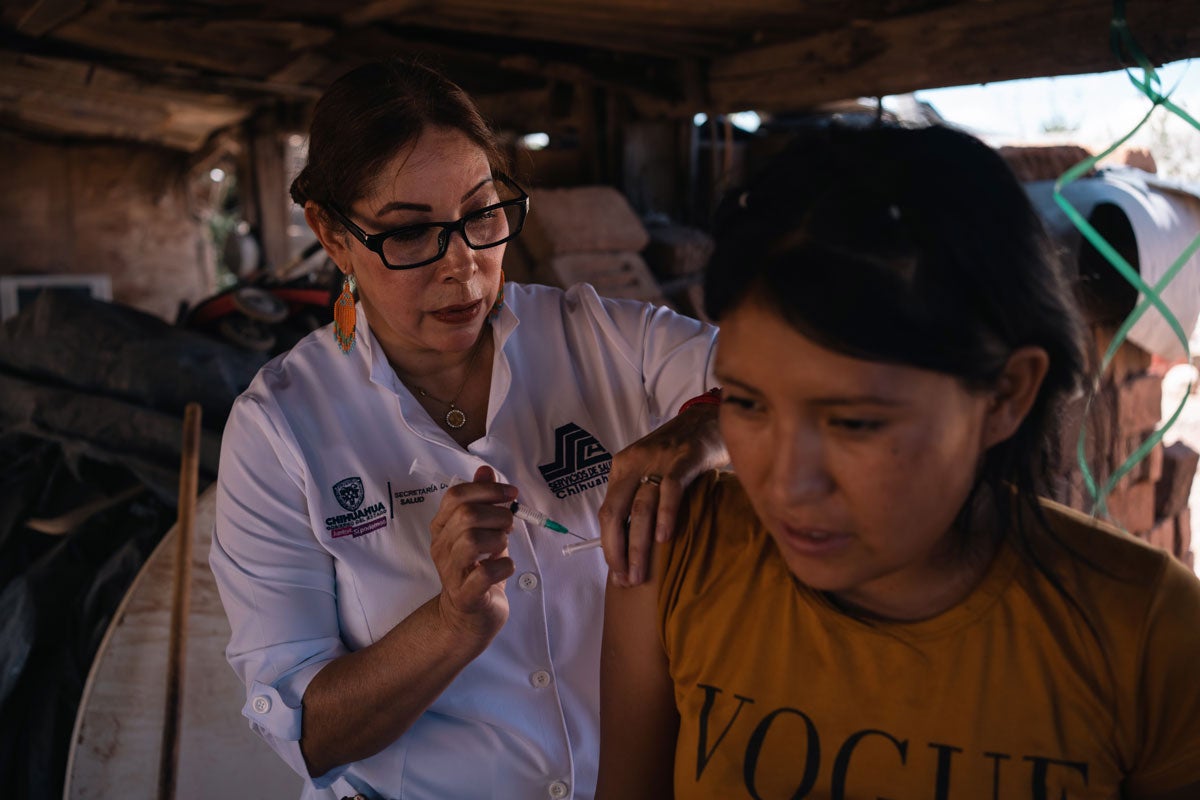 Nurse Julia vaccinating a young woman.