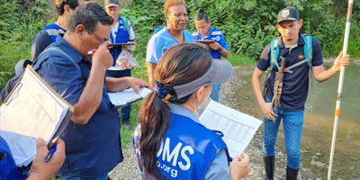 Grupo de personas representantes de la OPS ayudan a la población a descacharrar contra el dengue