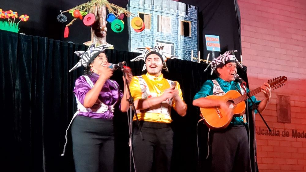 Tres personas disfrazadas arriba de un escenario