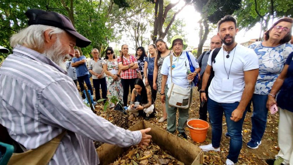 Grupo de personas reunidas frente a un disertante al aire libre