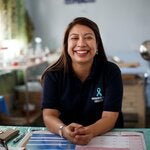 Health professional in her office, wearing a t-shirt with a cervical cancer ribbon