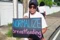 Lady holds sign - Normalize Breastfeeding