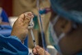 Health worker holds a syringe and a vial