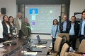 Grupo de personas de OPS y la academia reunios presencialmentey virtualmente