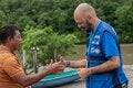 handshake between two men (PAHO personnel and a community leader). Setting: river front