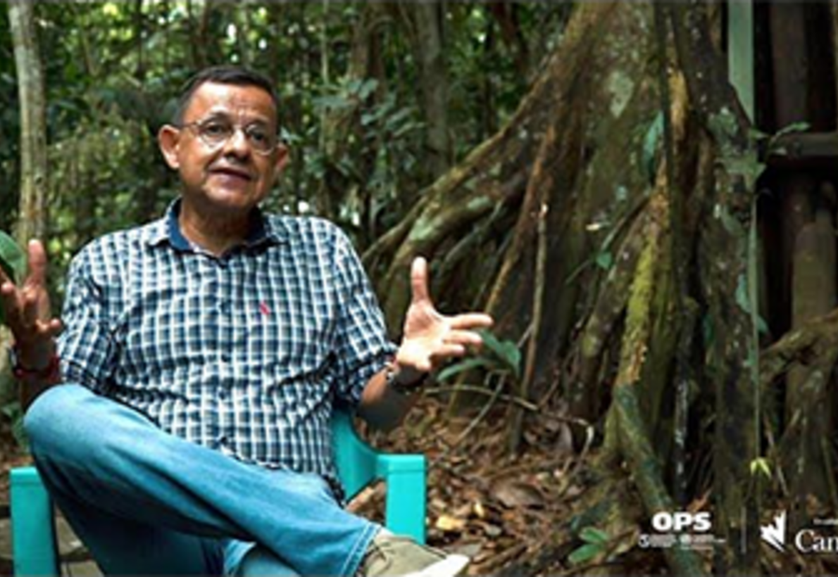 Hombre sentado en una silla en medio de la selva hablando frente a camara sobre tracoma en colombia