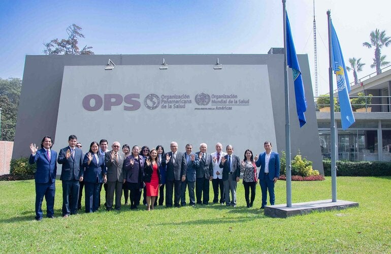 Foto grupal de los miembros del comité y autoridades en la fachada de la OPS Perú