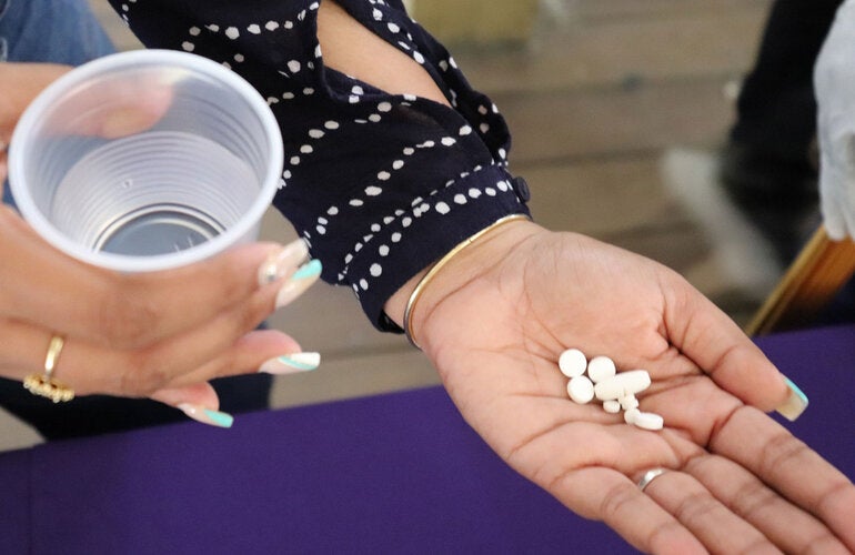 Una mujer tiene las pastillas en su mano para tratar la filariasis linfática