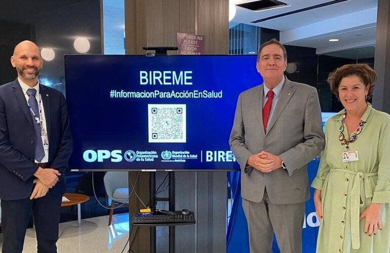 Photograph shows Dr. Barbosa Director of PAHO with João Paulo Souza, Director of BIREME, and Veronica Abdala, Manager at BIREME. They're standing in front of BIREME's booth at CD61.