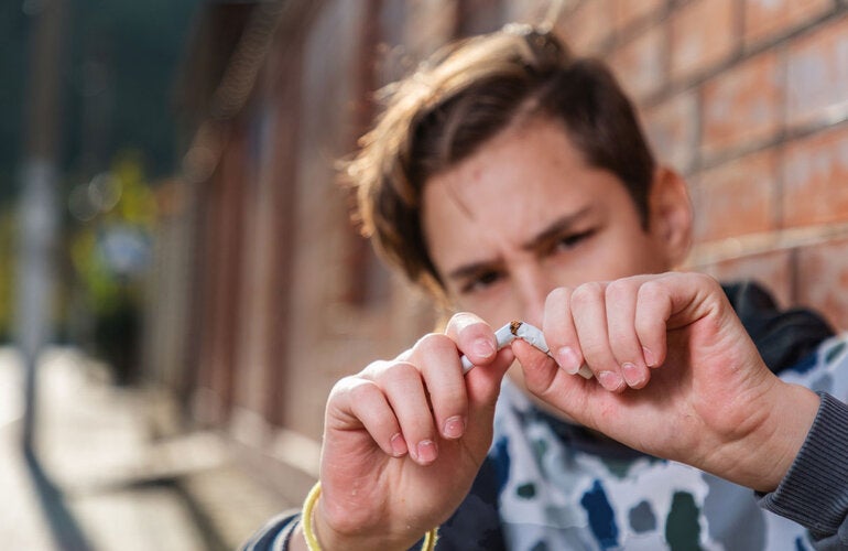 Young man breaking a cigarrette