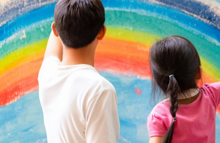 A boy and a girl looking at at painting of a rainbow