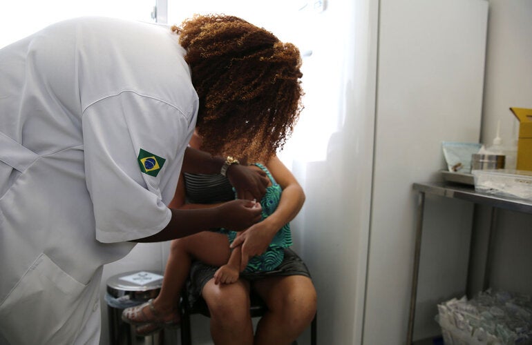 Health worker vaccinates child against yellow fever