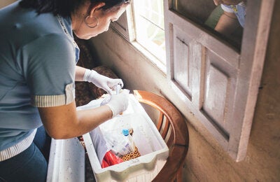 Displays and diagnoses from home: A worker at the Ministry of Health of Colombia, prepares to obtain blood samples from a person afflicted with dengue.