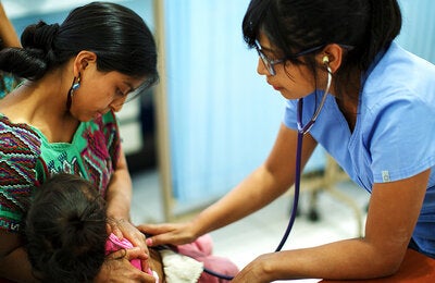 Una enfermera atendiendo a una bebé