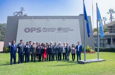 Foto grupal de los miembros del comité y autoridades en la fachada de la OPS Perú