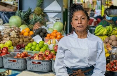 Mujer vende vegetales y frutas en mercado