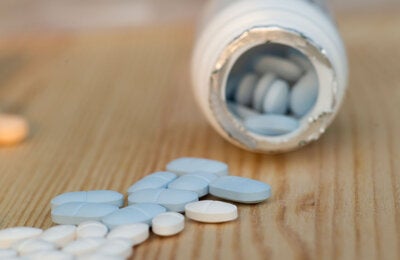 Pills spilling out of a jar of medicine