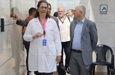 Laura Salvestrini, directora de la Clínica de Prevención del Cáncer, recorre las instlaciones del centro médico con representantes de la OPS