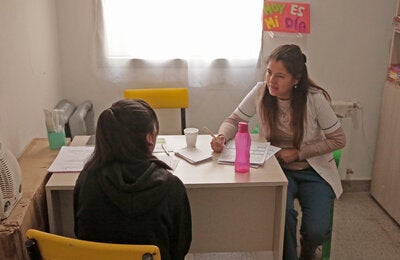 Mujer en una clínica interactuando con una doctora