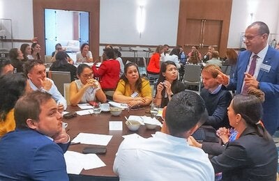 Dr Gabriel Vivas Francesconi, PAHO/WHO Representative for Trinidad and Tobago, Aruba, Curacao, Sint Maarten, Bonaire, St Eustatius and Saba (standing), facilitates one of the working group sessions during the consultation