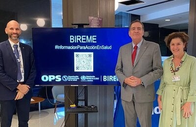 Fotografía muestra al Dr. Barbosa Director de la OPS con João Paulo Souza, Director de BIREME, y Veronica Abdala, Gerente de BIREME. Están parados frente al stand de BIREME en CD61.