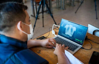 Trabajador de salud utiliza tecnología para identificar la presencia de tuberculosis en el paciente.