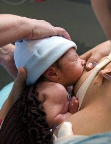 woman breastfeeding a premature baby