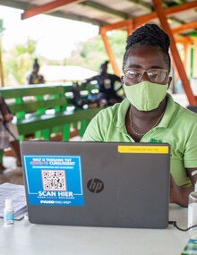 Health worker inputs data onto computer