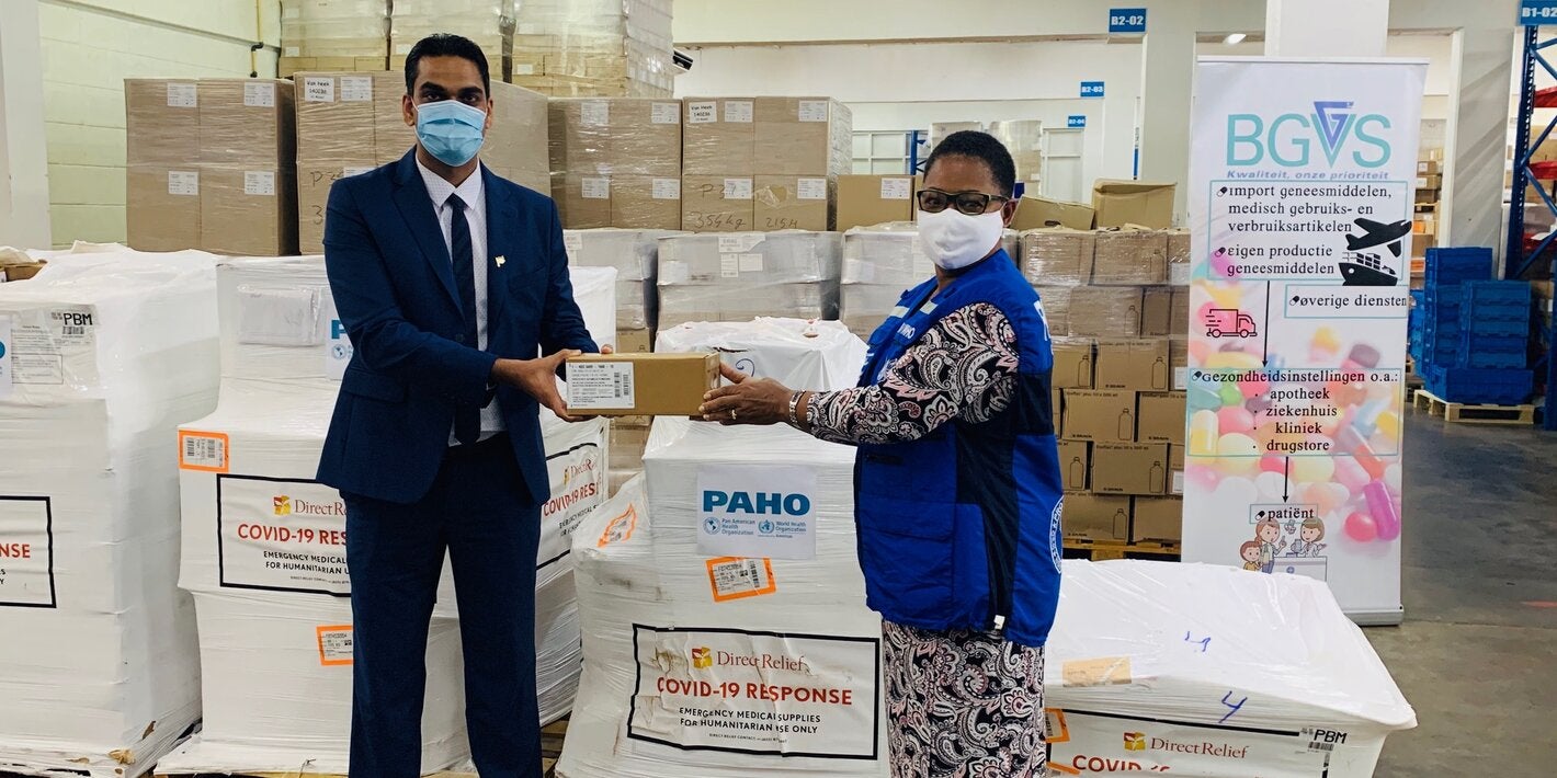 Dr. Karen Lewis-Bell, PAHO/WHO Representative in Suriname hands over a donation of COVID-19 supplies for case management to Dr. Amar Ramadhin, Minister of Health