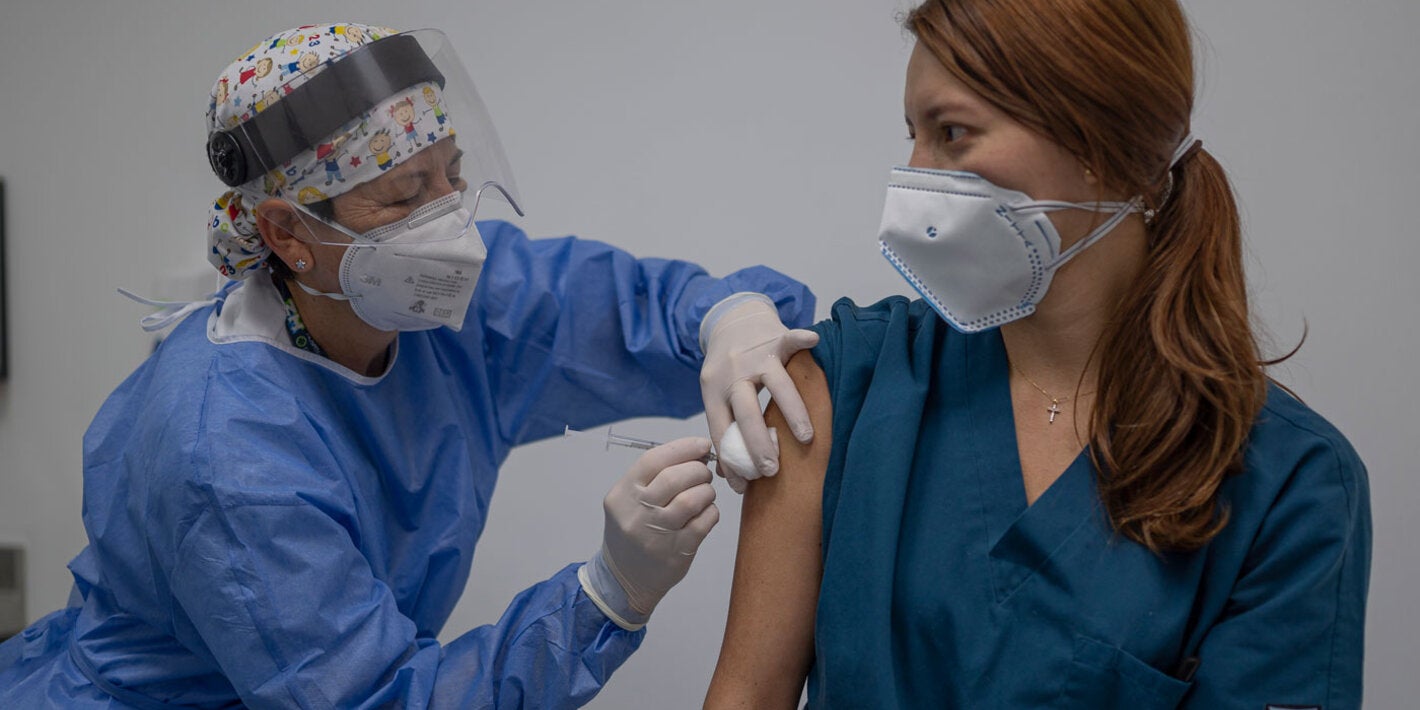 Enfermera aplicando vacuna a mujer