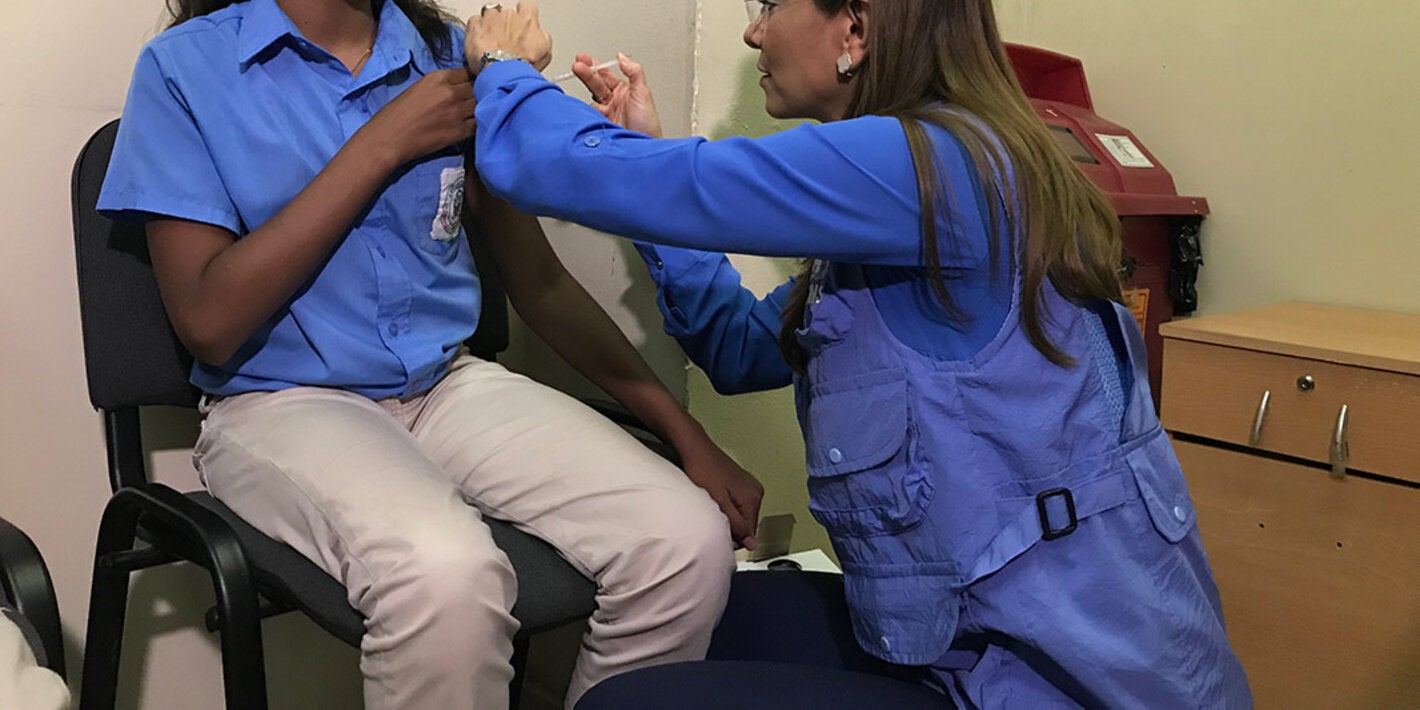 Representante vacunando a niña durante la inauguración 