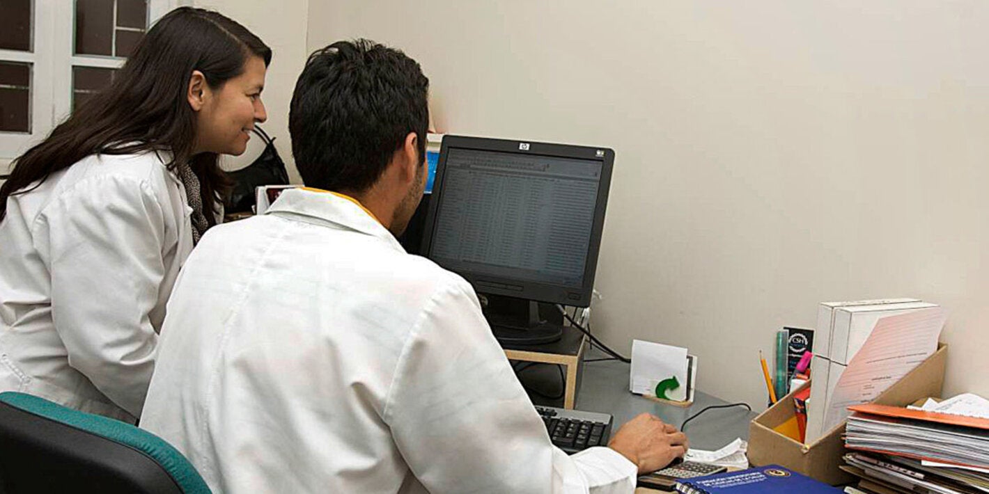 Two health workers looking at a computer monitor.