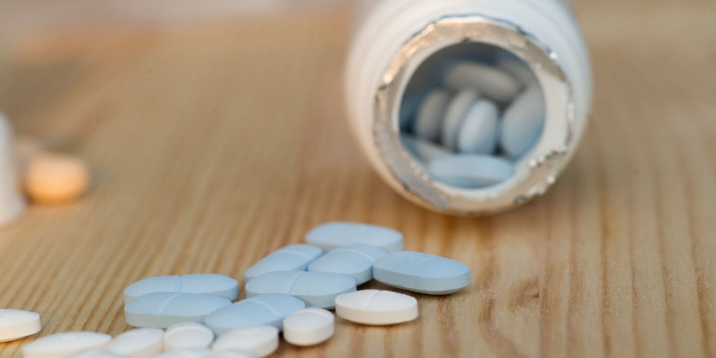 Pills spilling out of a jar of medicine