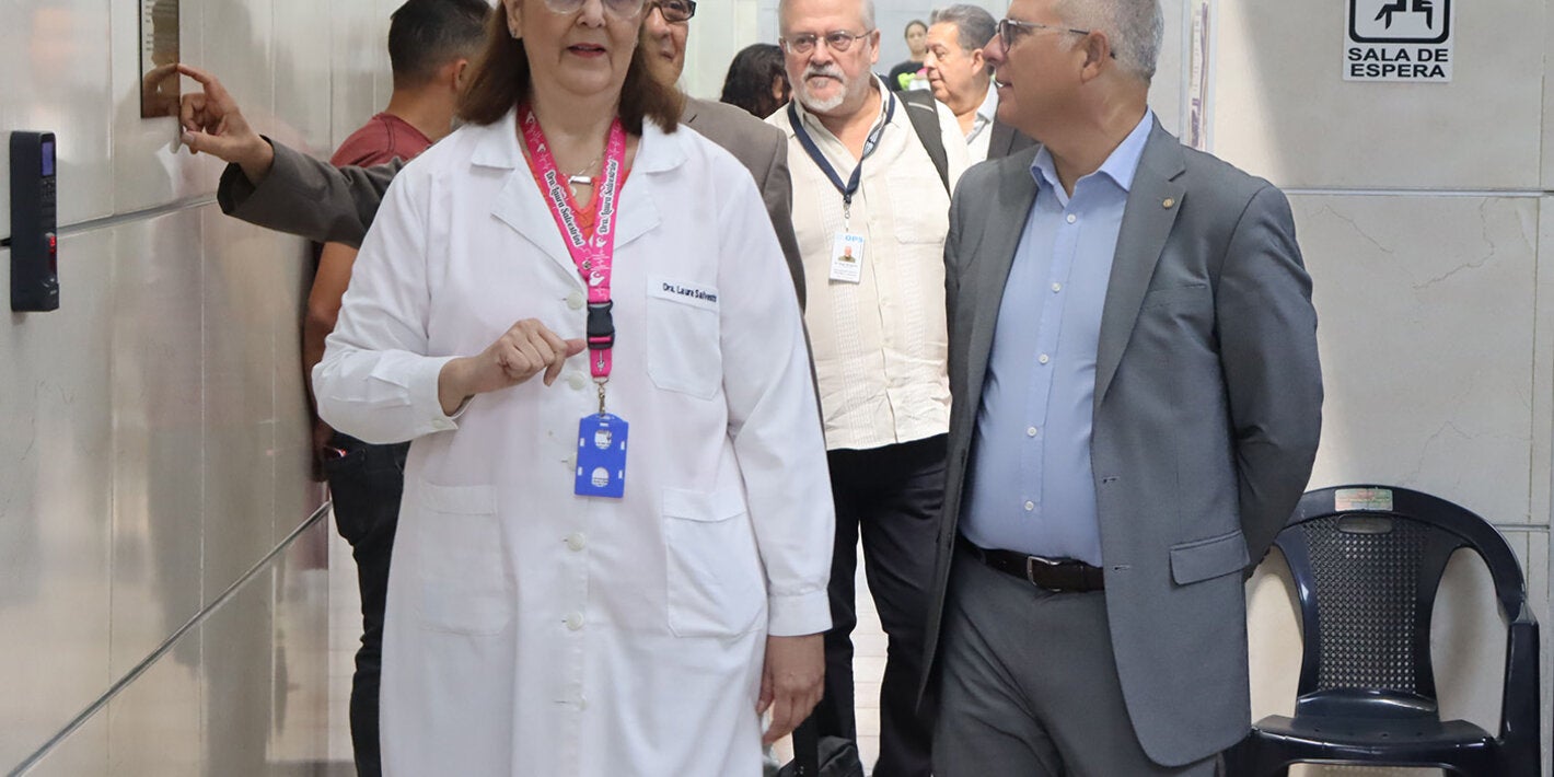 Laura Salvestrini, directora de la Clínica de Prevención del Cáncer, recorre las instlaciones del centro médico con representantes de la OPS