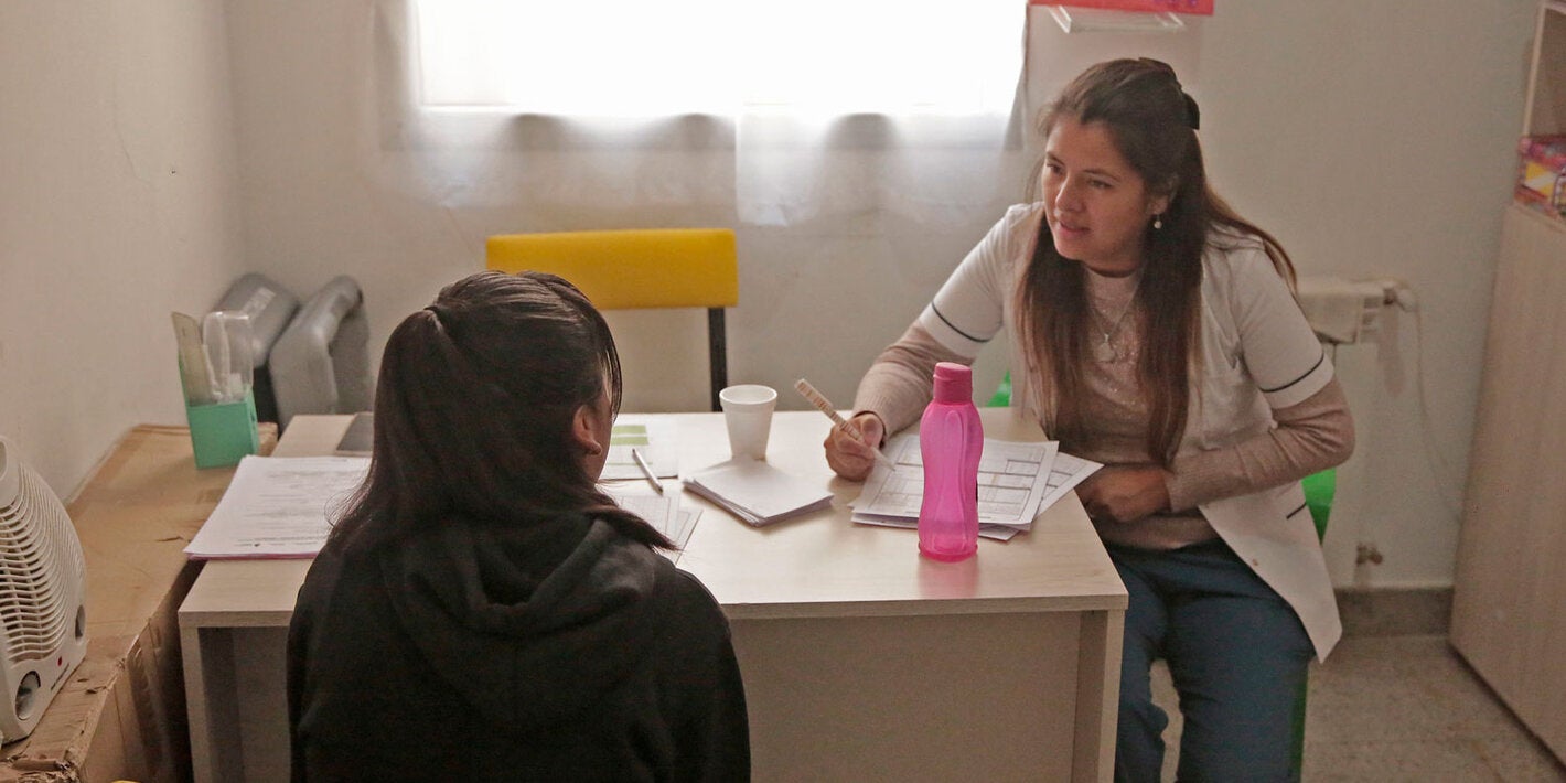 Woman at a clinic talking to female doctor